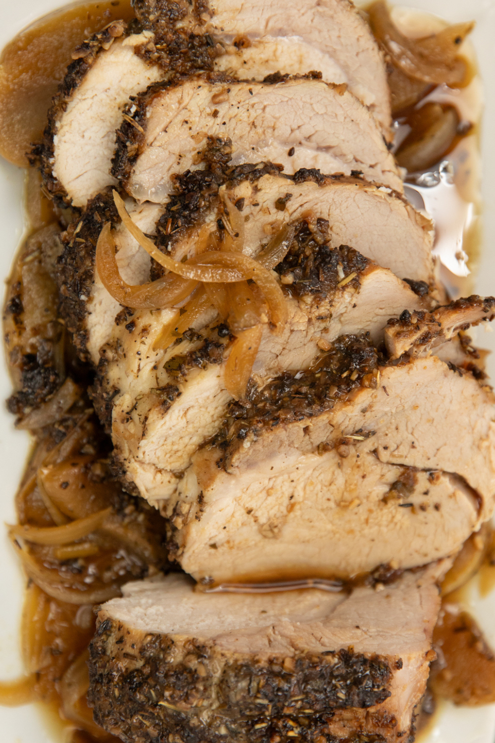 A pork loin roast with crusty seasoning onions and apples. 