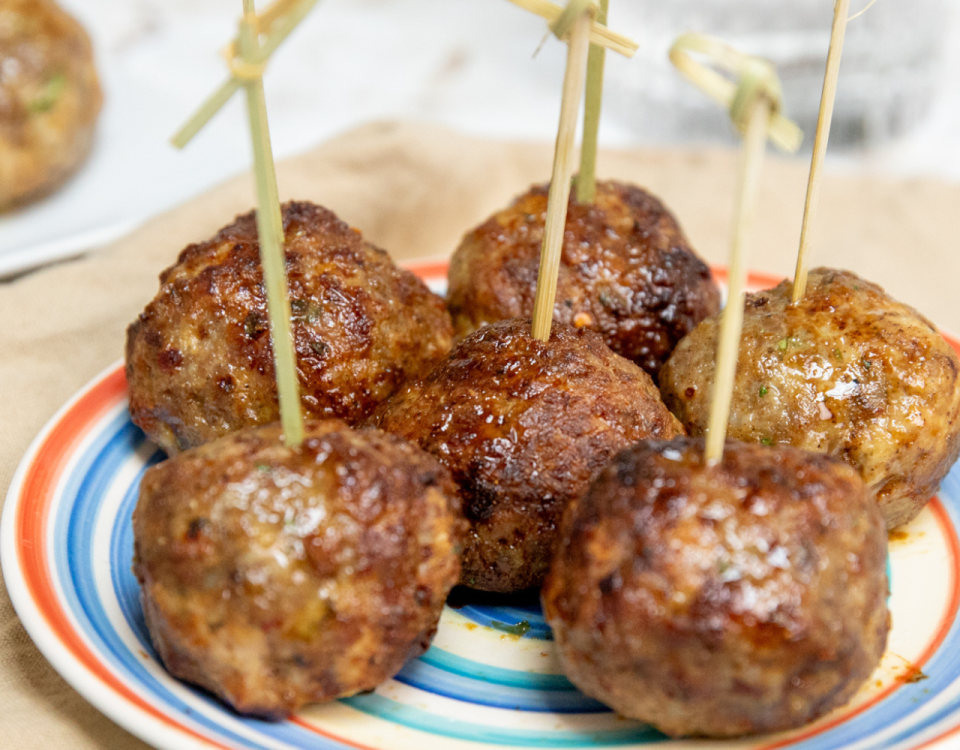 Air fryer pork meatballs with toothpicks.