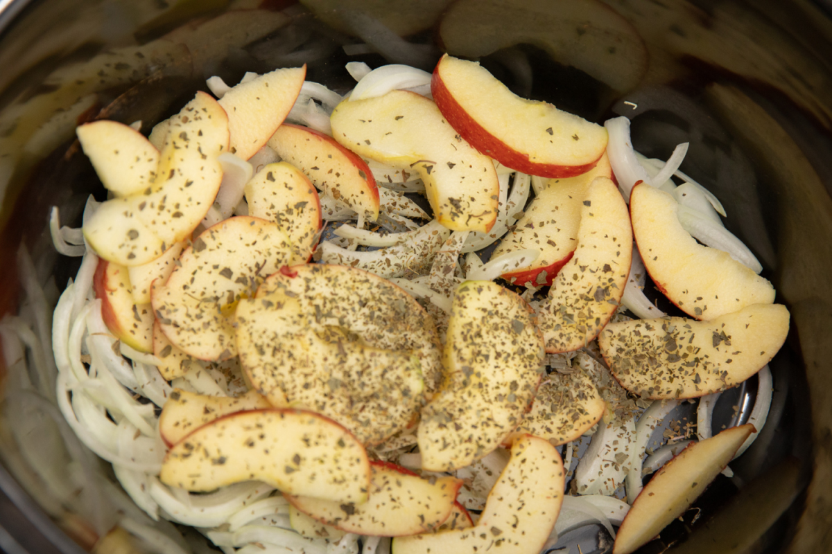 Apples, apple juice, onions, and dried garlic in a slow cooker. 
