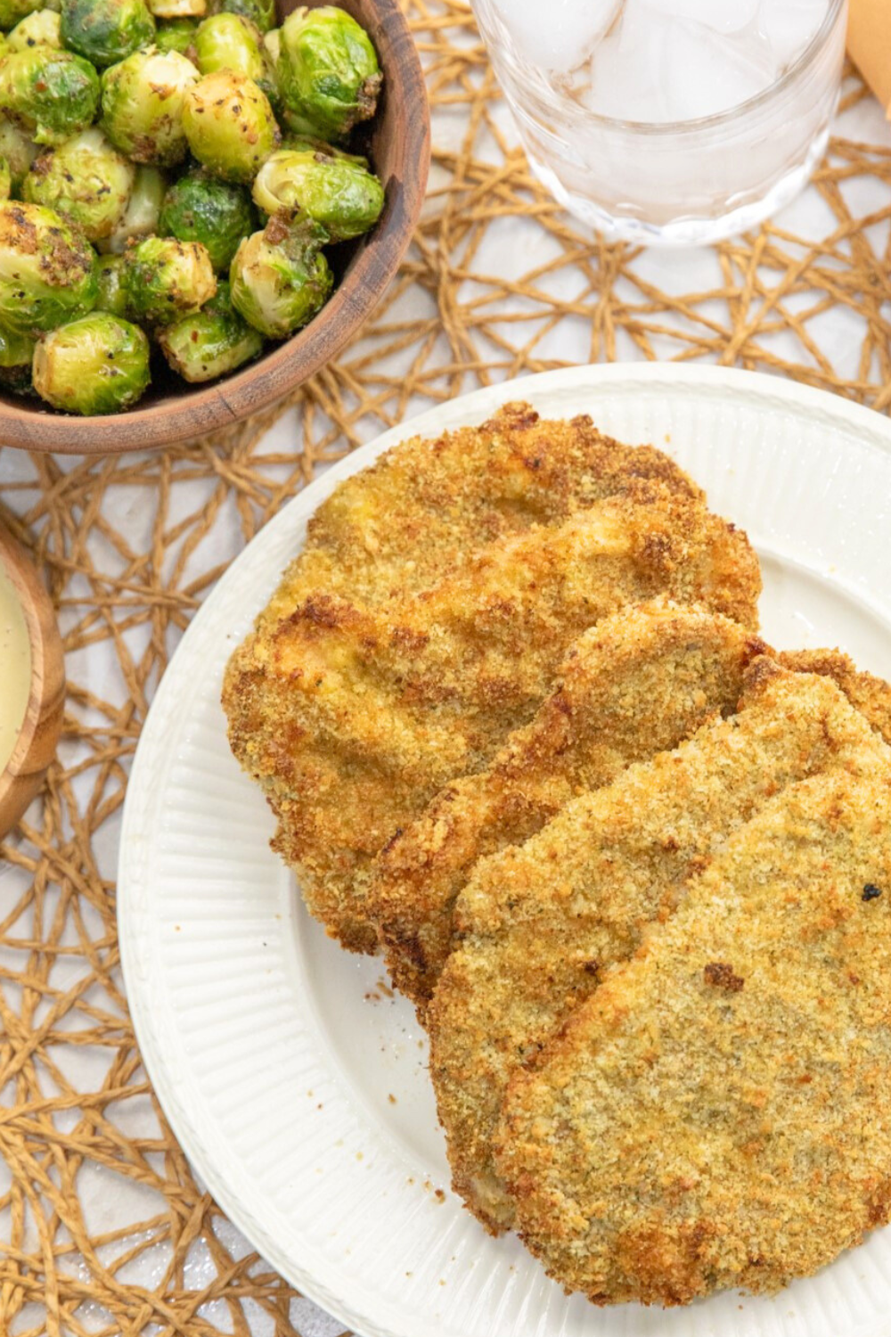Vertical beauty shot of air fryer pork cutlets on a white plate.
