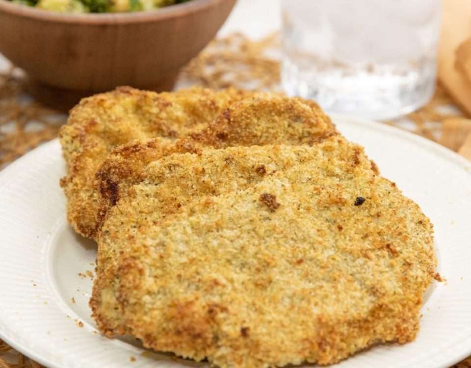 Breaded pork cutlets with a side of vegetables.