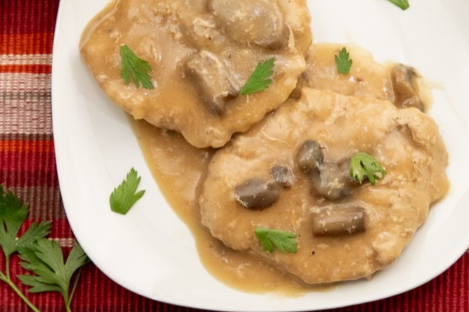 Crock Pot pork cube steak covered in gravy and mushrooms.