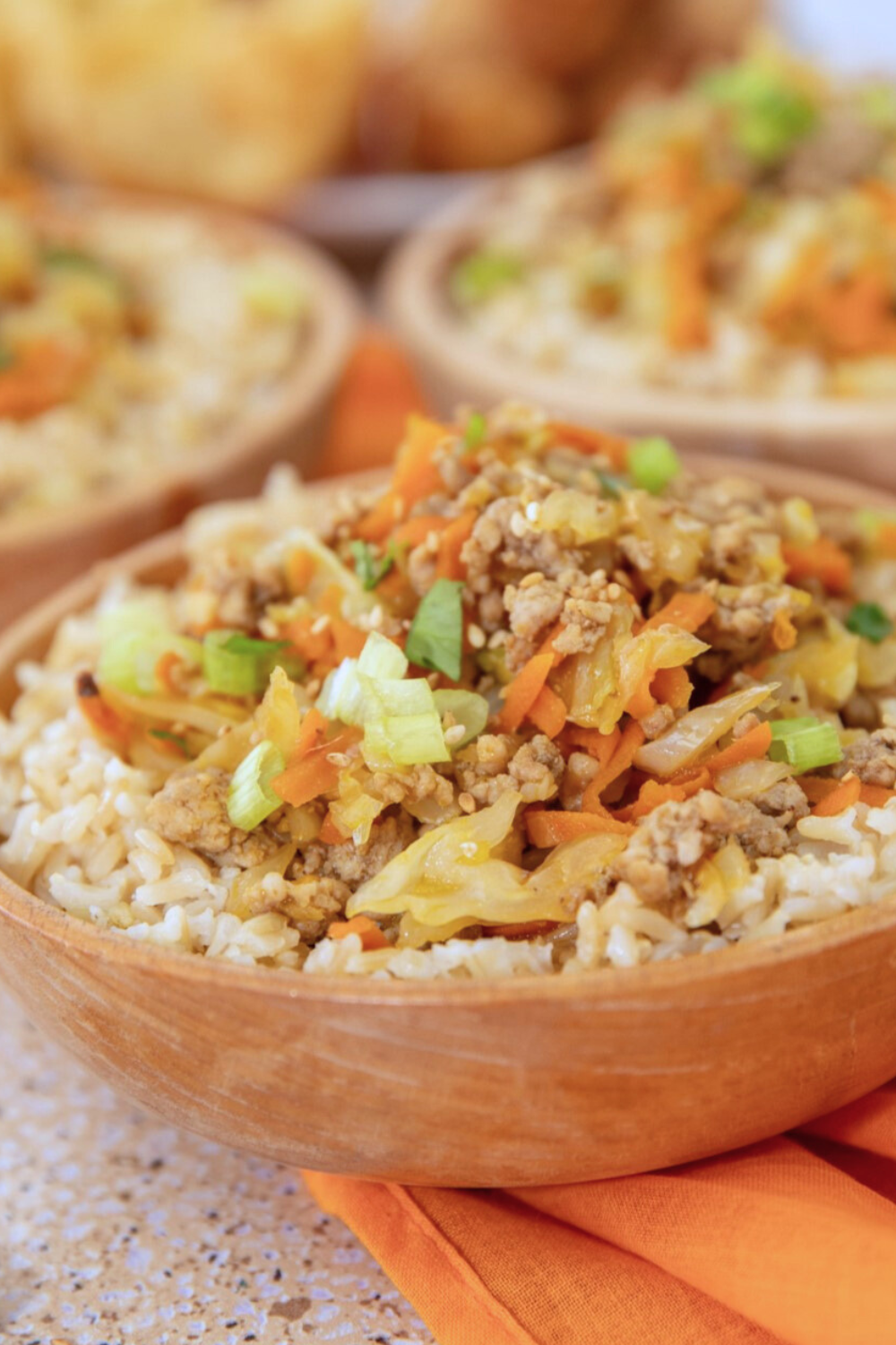 wooden-bowl-pork-eggroll Serving of pork egg roll in a wooden bowl with brown rice.