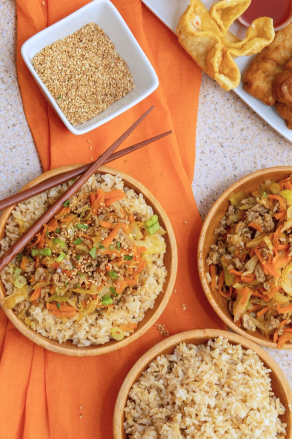 bowls-pork-egg-roll Sesame seed topping next to bowl of pork egg roll and rice.