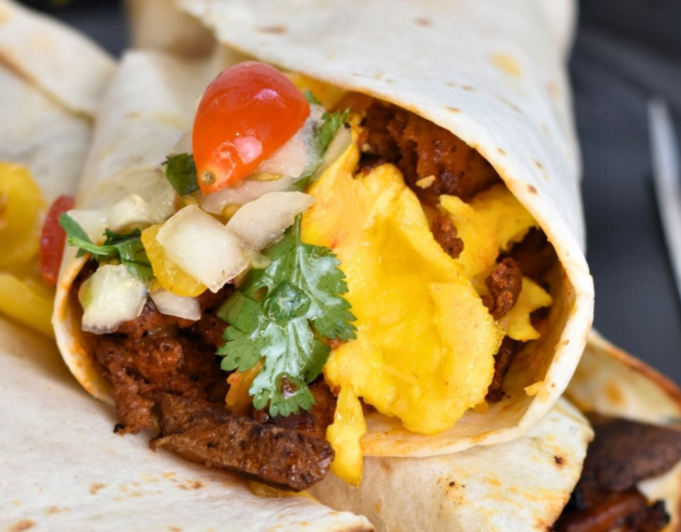 Breakfast burrito filled with eggs, pork chorizo and garnishes.