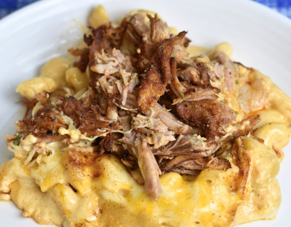 Pulled pork mac and cheese on a white plate.
